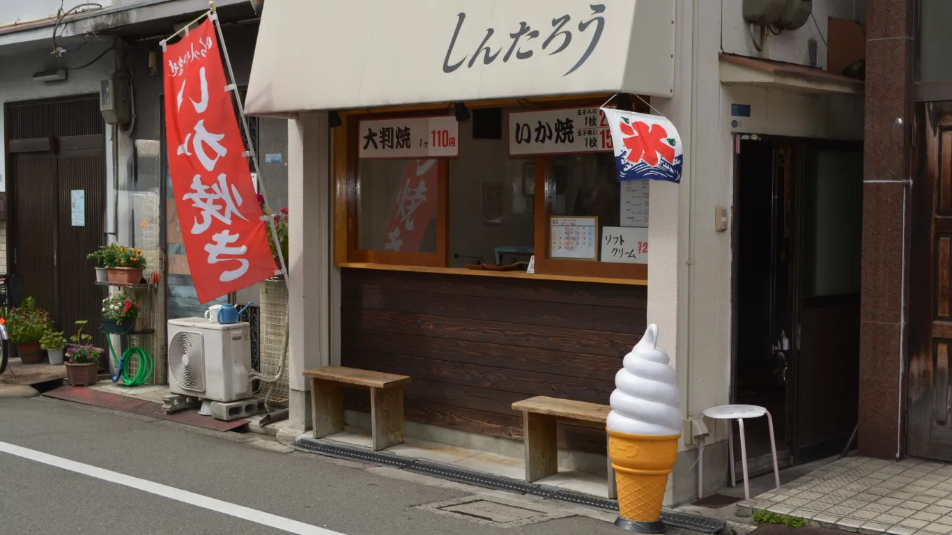 「しんたろう」の日よけを掲げた店構え。軒先に赤いのぼりとソフトクリームの模型が置かれている